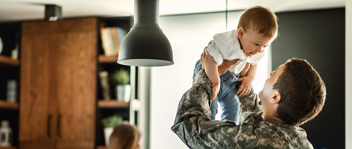 what is a USDA renovation loan A veteran lifting his child in their newly renovated living room