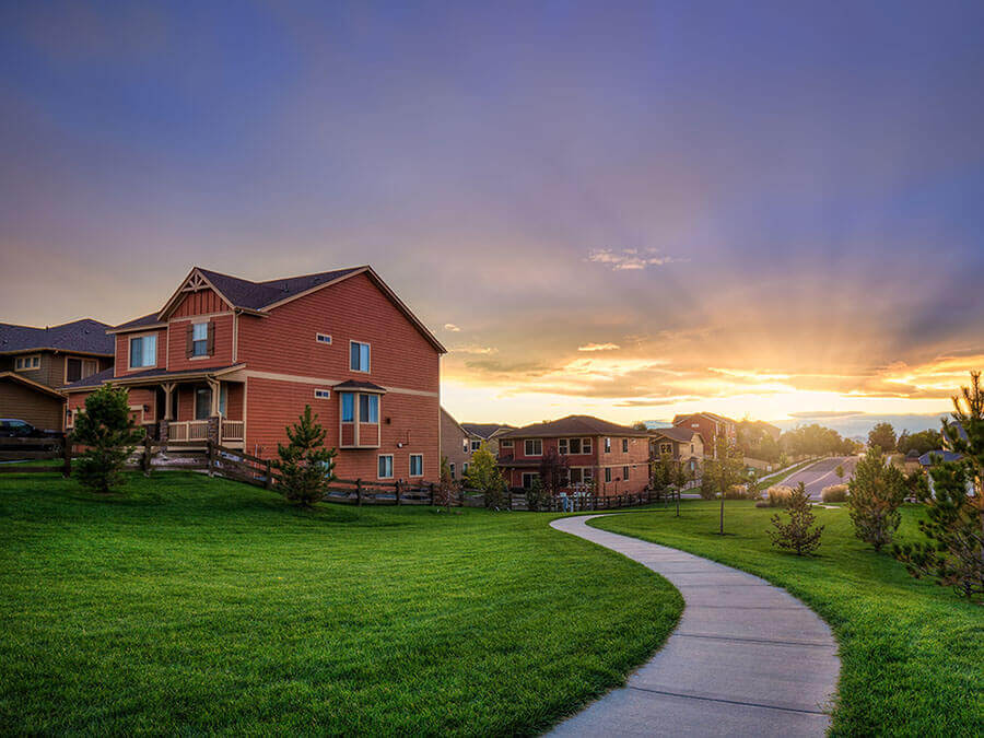 A suburban neighborhood with the sun setting down the street