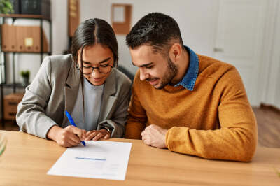 A man and a woman looking at documents to lower their debt to income (DTI) ratio.