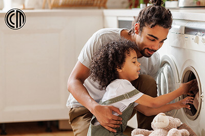 A father and daughter unload the dryer together in their energy-efficient home