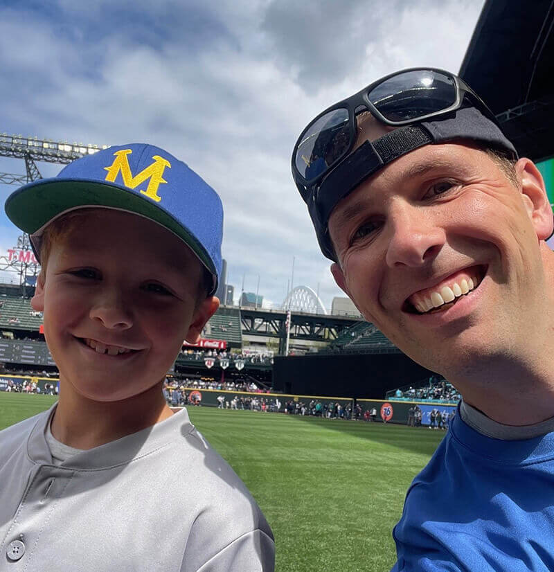 A homeowner with a child on his lap calculating whether to buy a new home or refinance his home loan