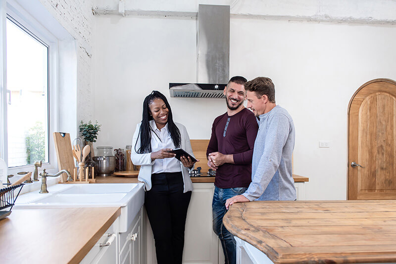 A realtor walking through a home with the homeowners discussing changes to increase its value