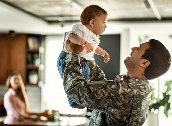 A veteran holding his child