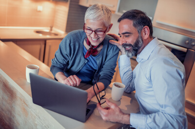 Mortgage lender reviews with female homebuyer what a mortgage is on a laptop.