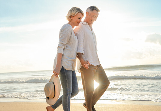 Homeowners walking on the beach after getting a reverse mortgage.