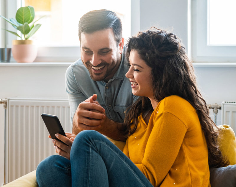 Couple smiling at their phone