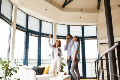 Couple tours a home during an open house with either a realtor or a real estate agent.