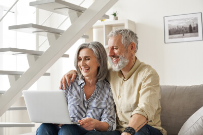 Old couple sitting on the couch.